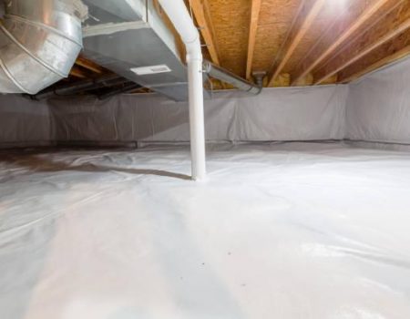 Crawl space fully encapsulated with thermoregulatory blankets and dimple board. Radon mitigation system pipes visible. Basement location for energy saving home improvement concept.